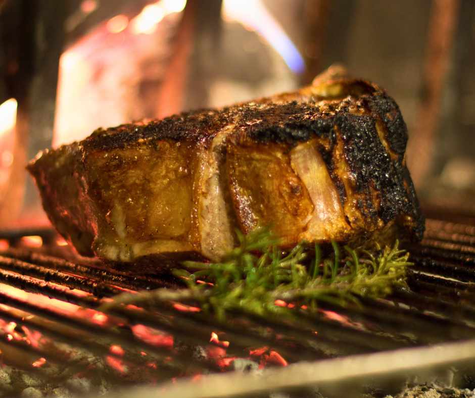 Traditional Florentine steak grilling over open flame