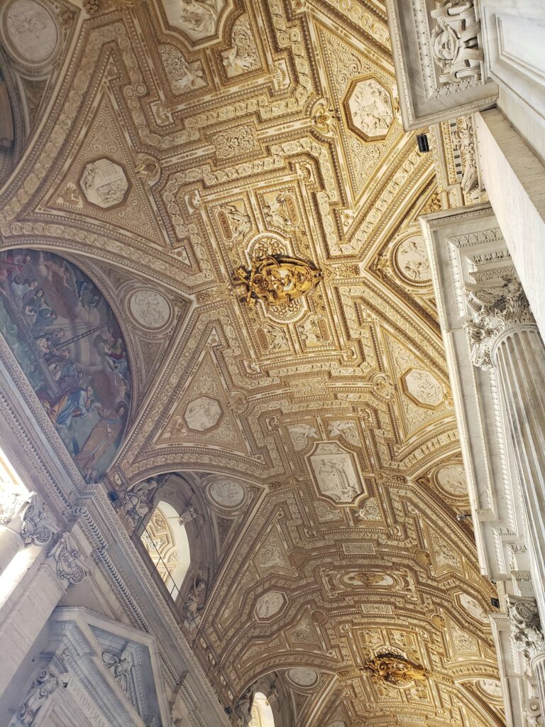 Intricate golden coffered ceiling perspective in the Vatican Museums.