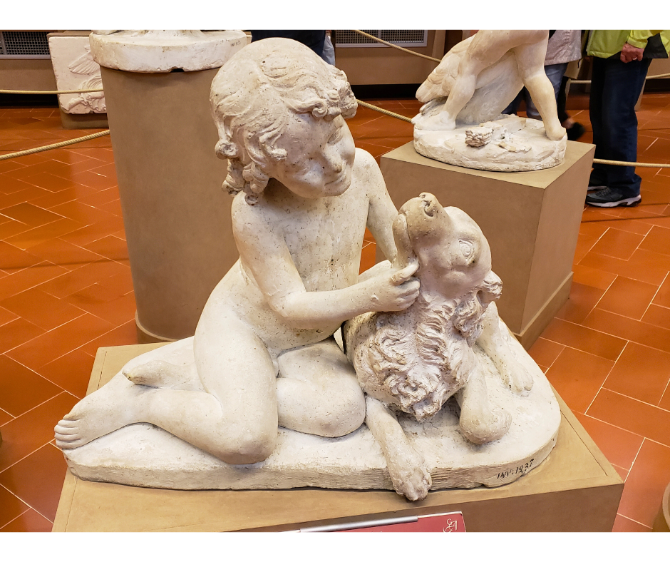 Statue of a child playing with the dog