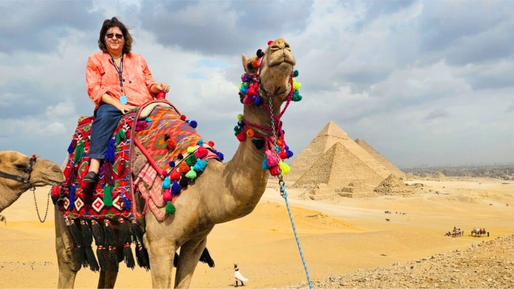 Woman on a camel in front of the Great Pyramids in Egypt