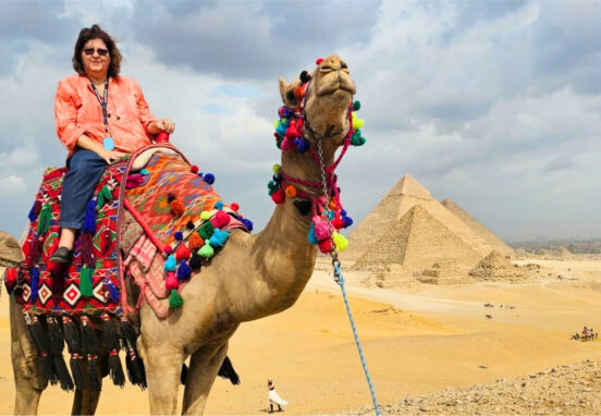Woman on a camel in front of the Great Pyramids in Egypt