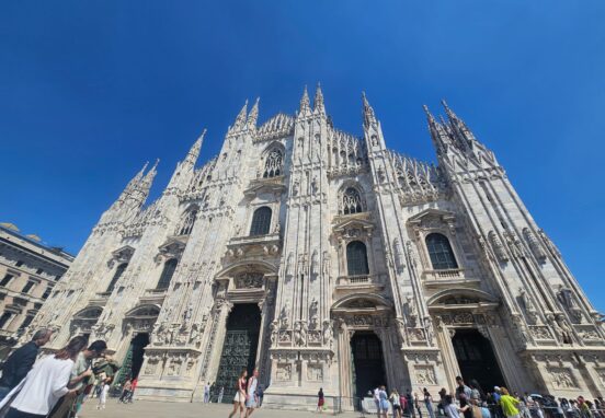 Front exterior of the Milan Cathedral with its Gothic spires and detailed marble facade