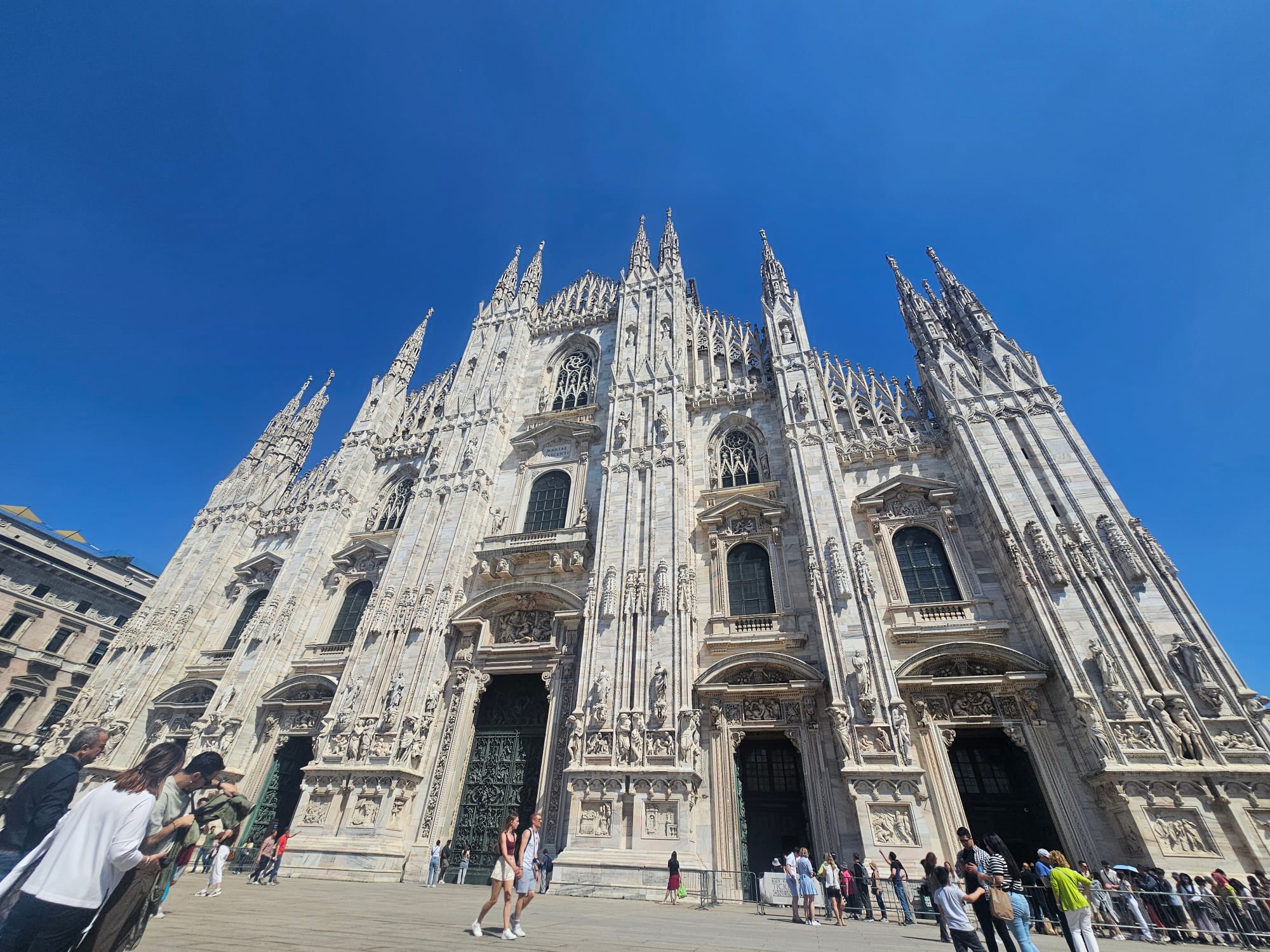 Front exterior of the Milan Cathedral with its Gothic spires and detailed marble facade